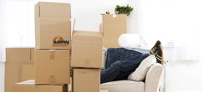 person on couch behind stack of boxes