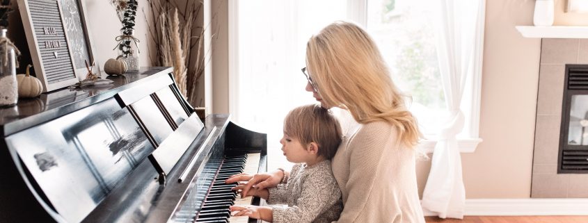 mom and son having quality time playing music on their piano