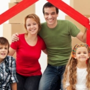 Happy family with boxes behind them moving in Greensboro NC